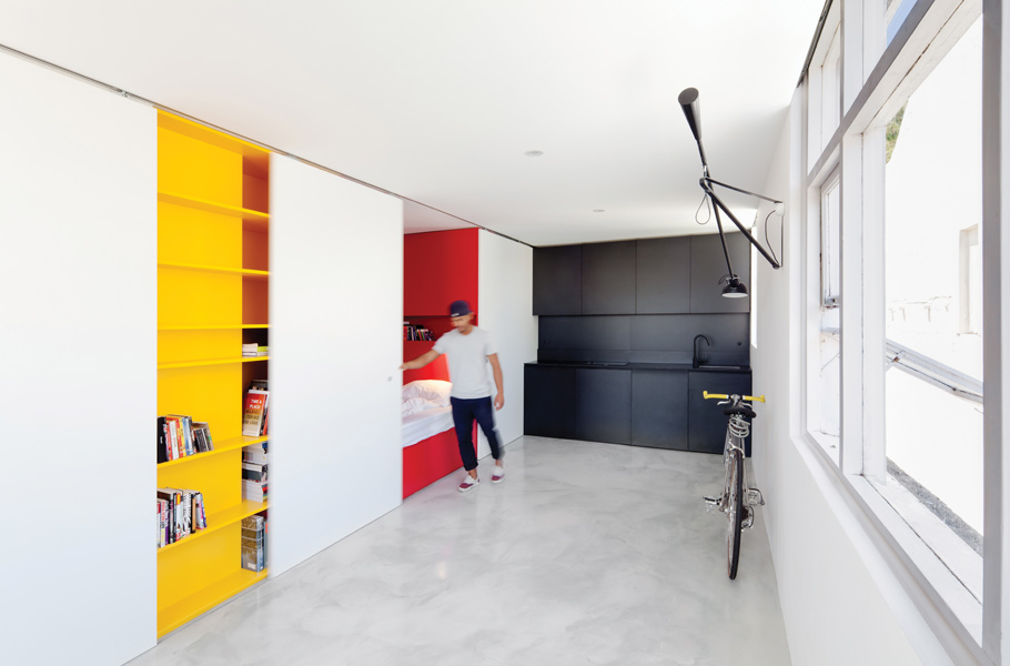 The workings of the apartment are contained within a joinery unit and concealed by sliding doors