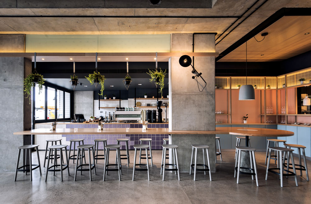 The shared bar that is situated between the existing concrete columns delineates the cafe from the restaurant.