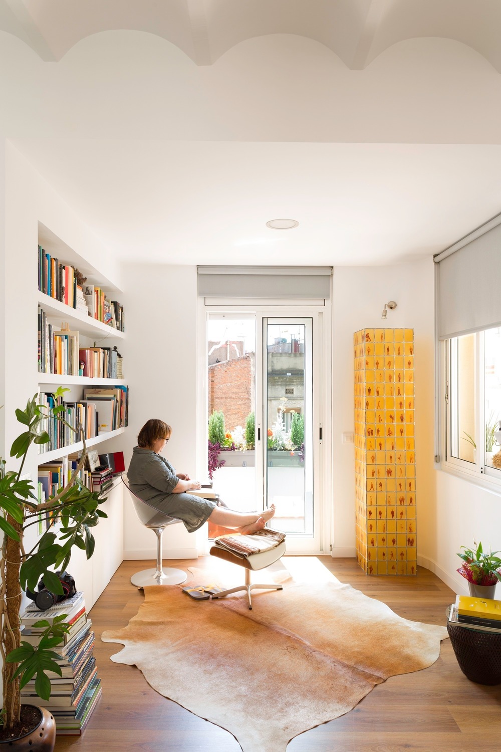 The owner sits by the window in her newly design apartment