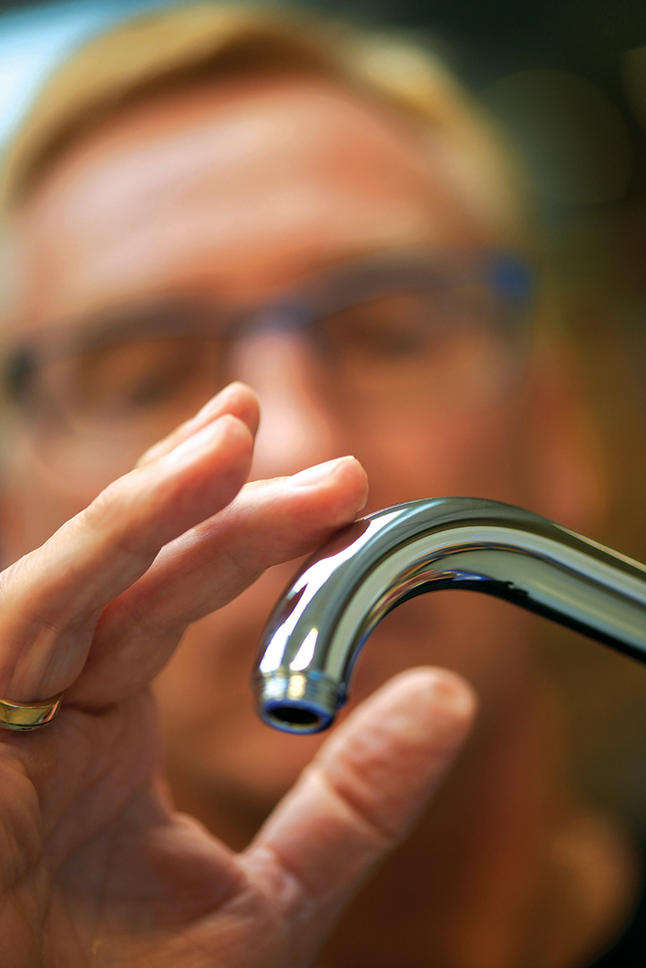 A designer inspects a VOLA tap