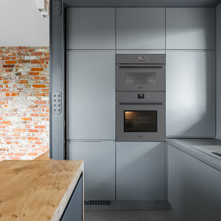 Gray kitchen wall with built-in oven and microwave