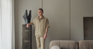 Joss Knight, interior designer, standing in a living room with a neutral earth toned colour palette.