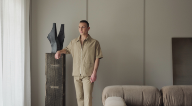 Joss Knight, interior designer, standing in a living room with a neutral earth toned colour palette.