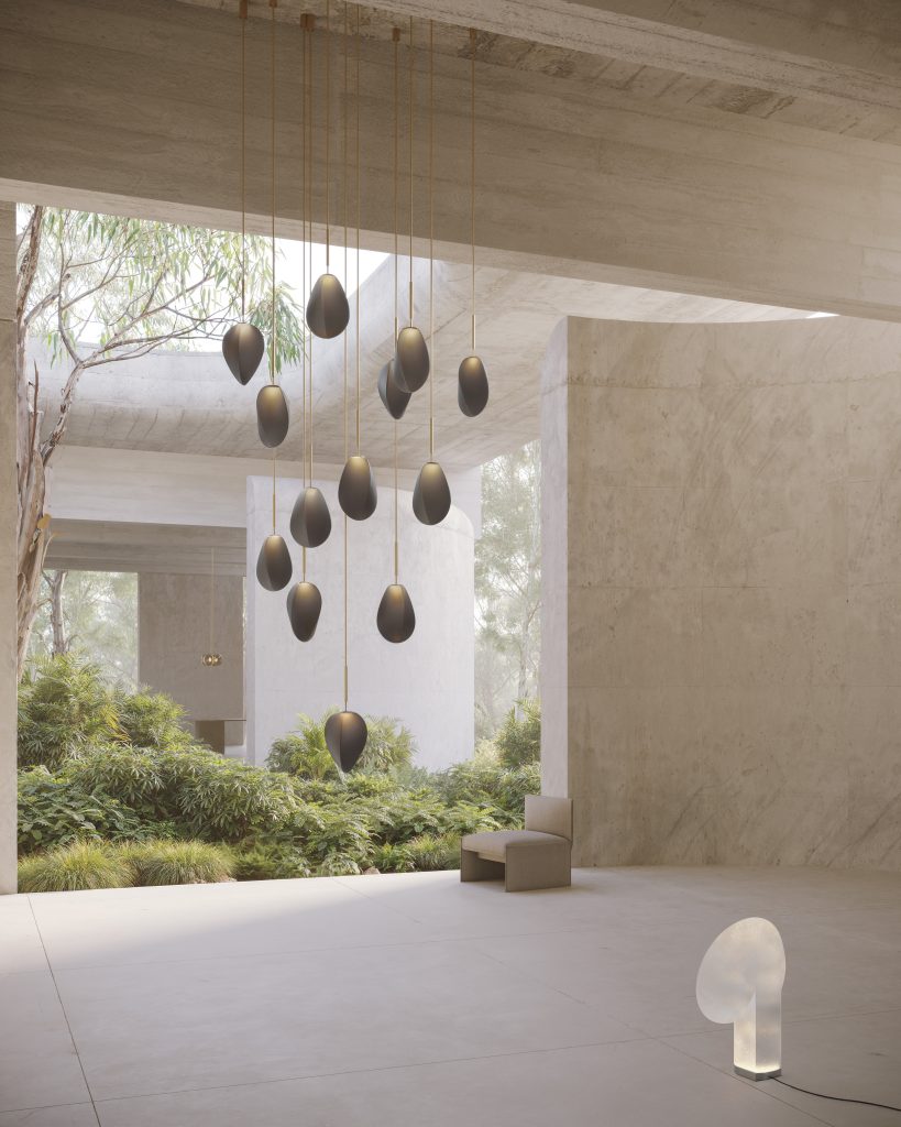 An architectural image of grey walls opening onto a space filled with shrubs and an array of pendant lights hanging in the middle. Ross Gardam