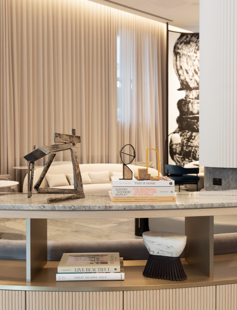 Lanson Place. An interior low table with small sculptures on it and coffee table books below
